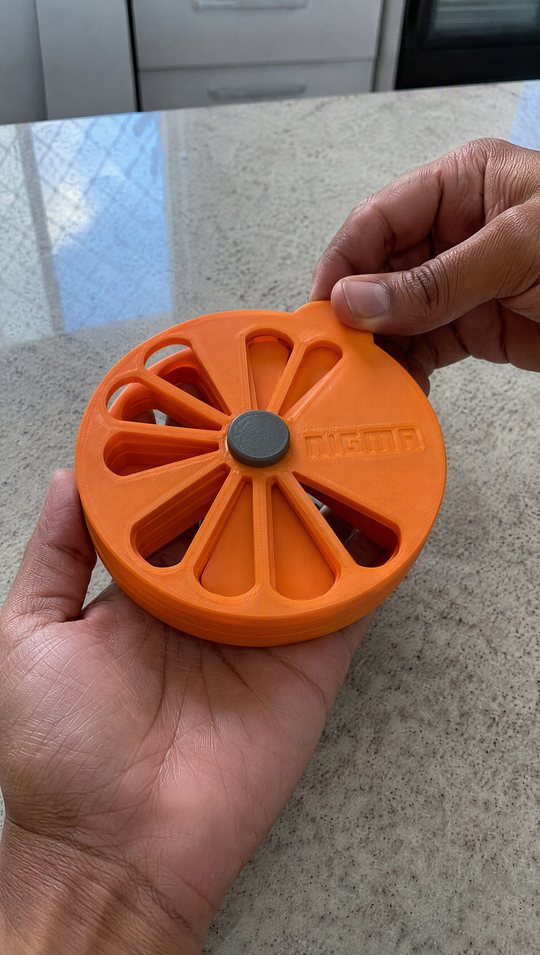 Macro das mãos girando o disco de cima do Nigma P5, com as linhas de impressão 3D visíveis