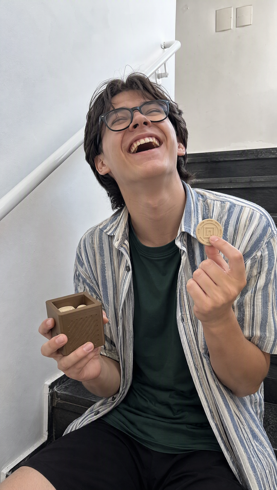 Adolescente rindo com o cubo do Nigma P2 numa mão e um disco na outra